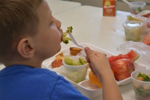 Dreyden Crawford, 6, enjoys a nutritious meal at PODER Learning Center on Thursday, June 25. Photo by Jesse Louden/VoiceBox Media